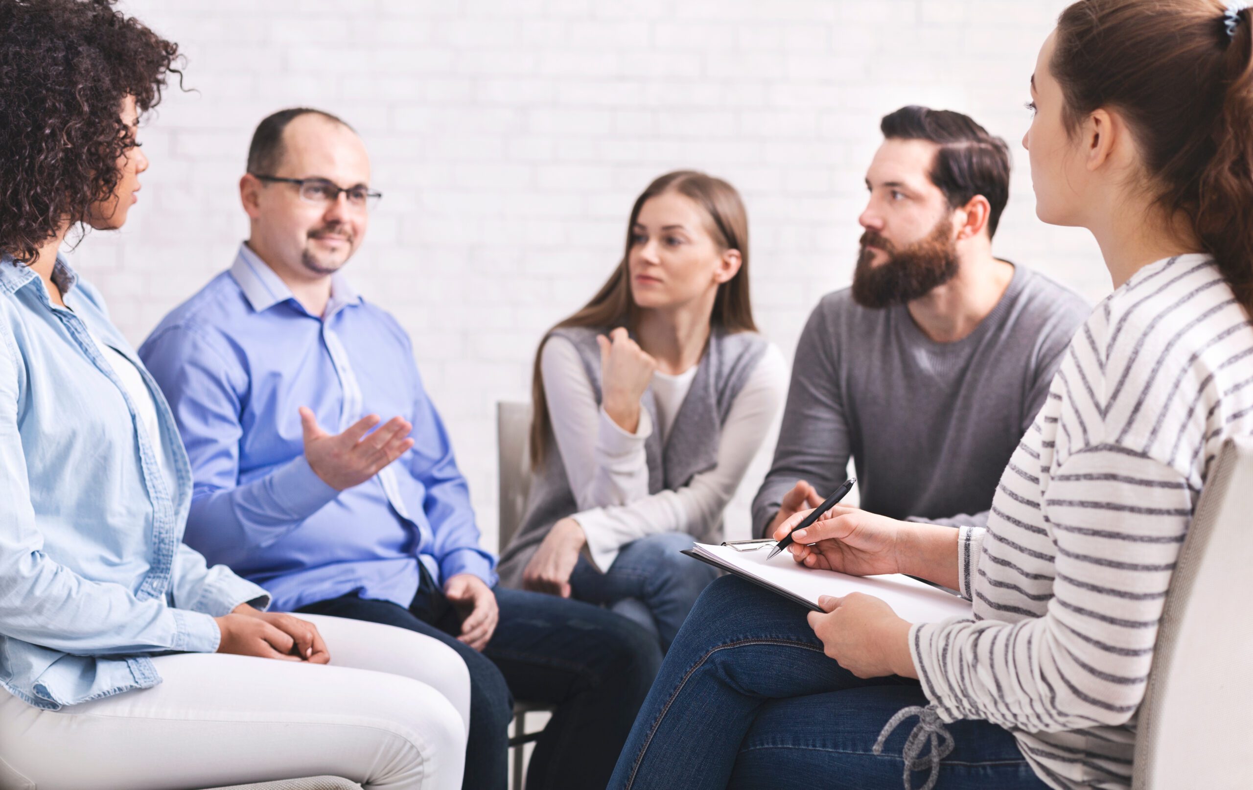 Man talking with psyhiatrist at rehab group meeting