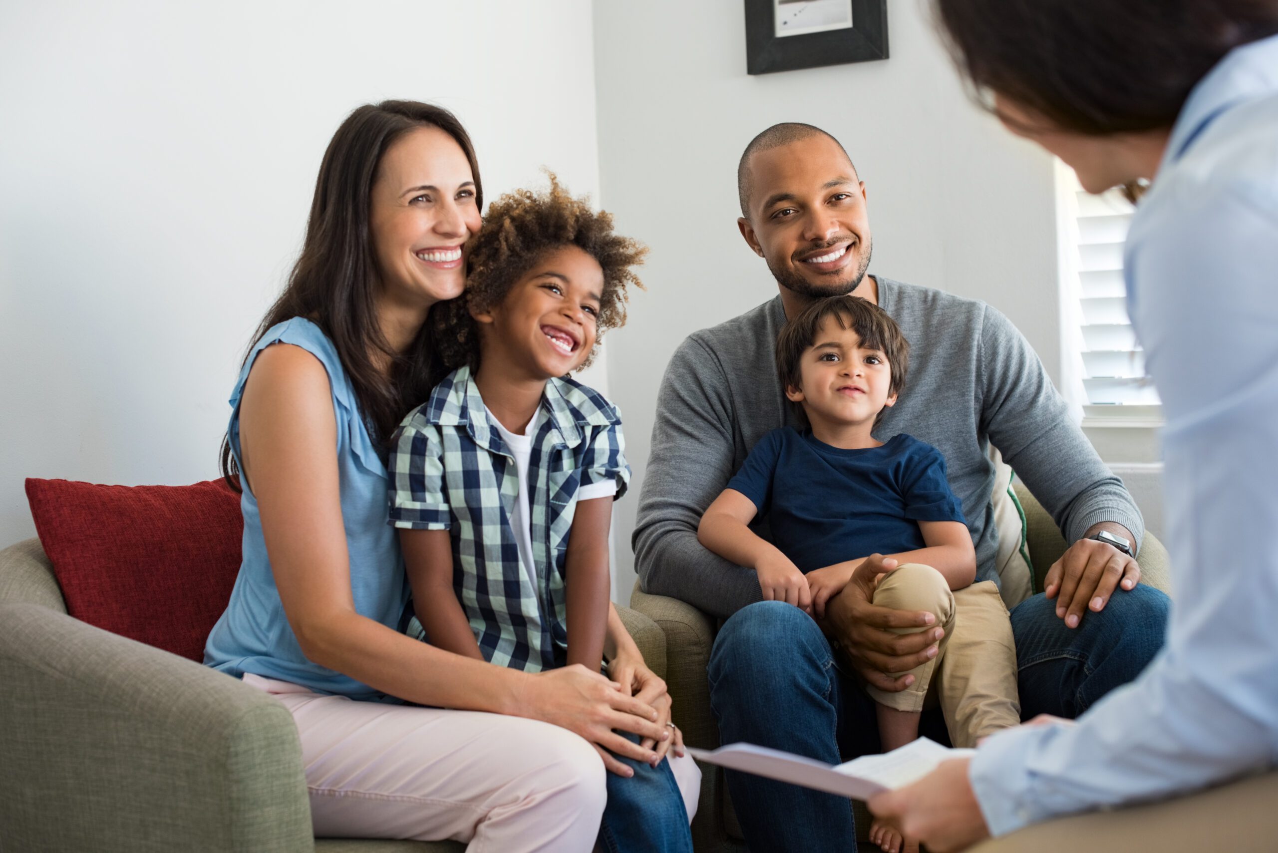 Family sitting on couch and talking with family counselor